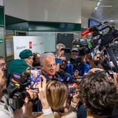 Velasco attorniato da giornalisti all'arrivo a Malpensa